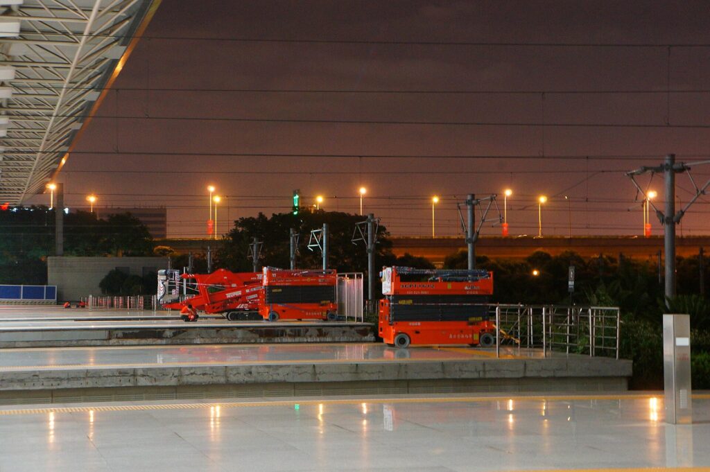 Plataforma elevadora de tijera levantada junto a la fachada lateral de un edificio