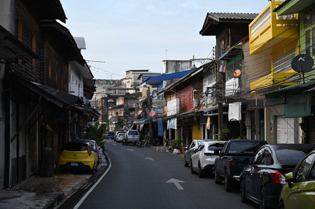 Calle estrecha de casas de dos alturas con fachadas de color y aceras muy angostas