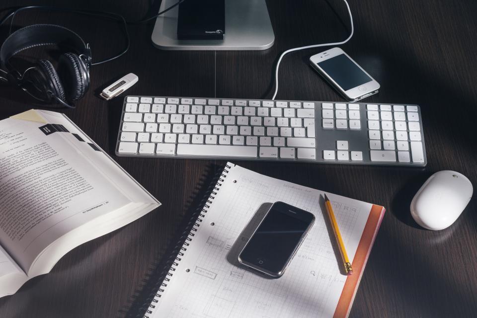 Cuaderno con anotaciones y una calculadora sobre una mesa junto a un bolígrafo