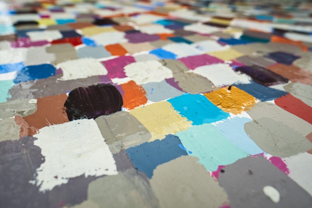Muestras de pintura en tonos rosa apagado, tierra y gris ordenadas sobre una mesa
