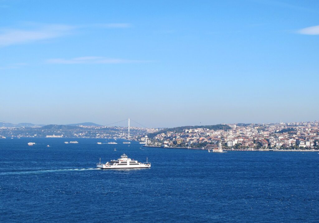 Ferry cruzando el estrecho con la silueta de la ciudad al fondo