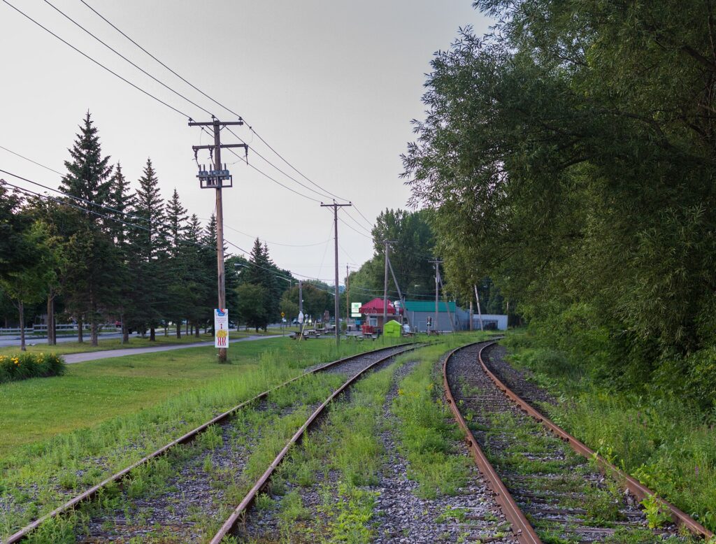Vías de tren atravesando la ciudad con bloques de viviendas al fondo