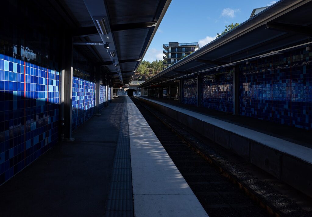 Andén de metro en una estación periférica de Estocolmo con carteles y escaleras al fondo