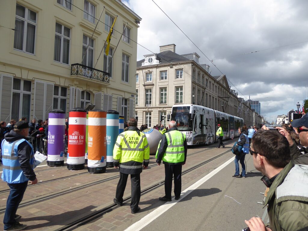 Parada de tranvía urbana con vías dobles y edificios bajos alrededor