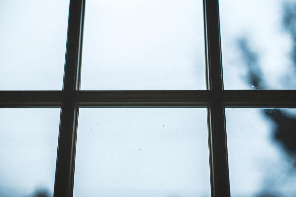 Ventana con un dibujo trazado sobre el cristal y el paisaje urbano visible al fondo