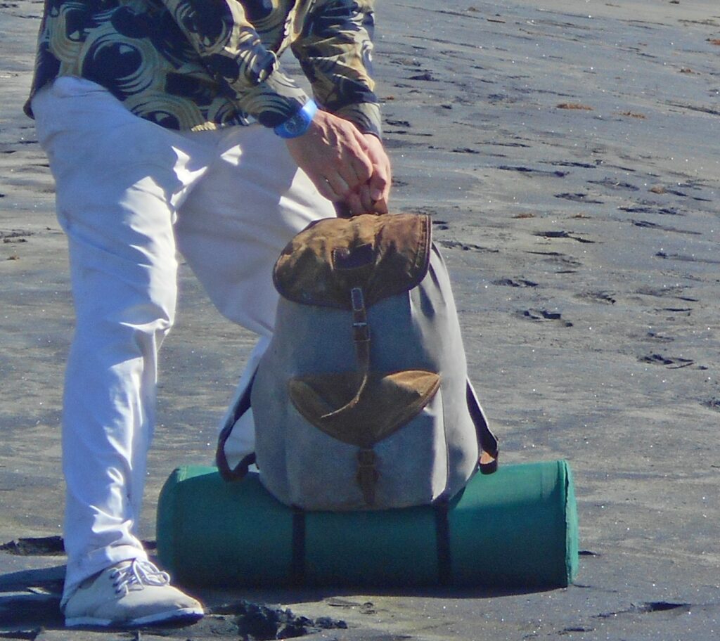 Mochila pequeña abierta con una cámara y un objetivo colocados en la parte alta