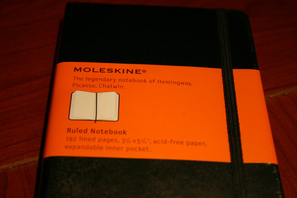 Libreta pequeña de bolsillo con una tabla dibujada a mano sobre una mesa de café